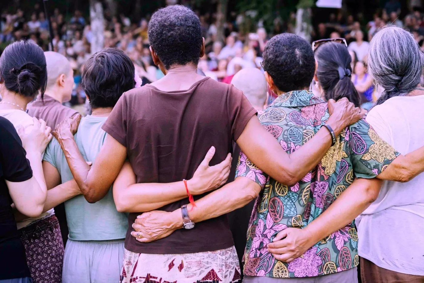 Arms embraced across shoulders, backs turned to the camera