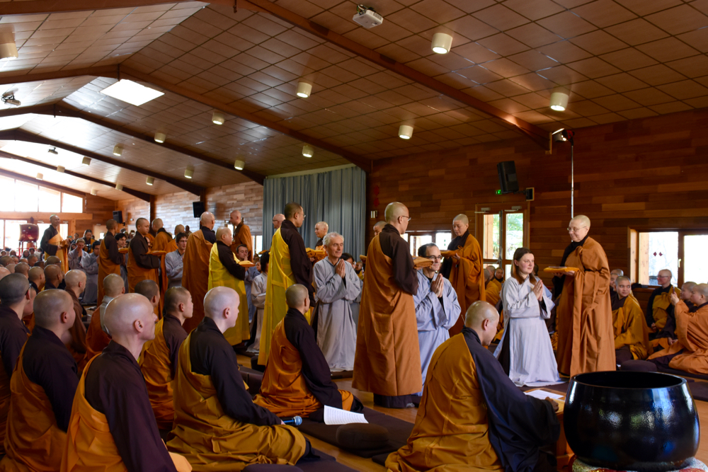 La cérémonie continue avec la présentation formelle de la robe sanghati couleur safran d'un(e) monastique bouddhiste. 
