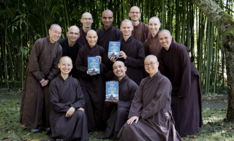 Monastics smiling with book - wide landscape